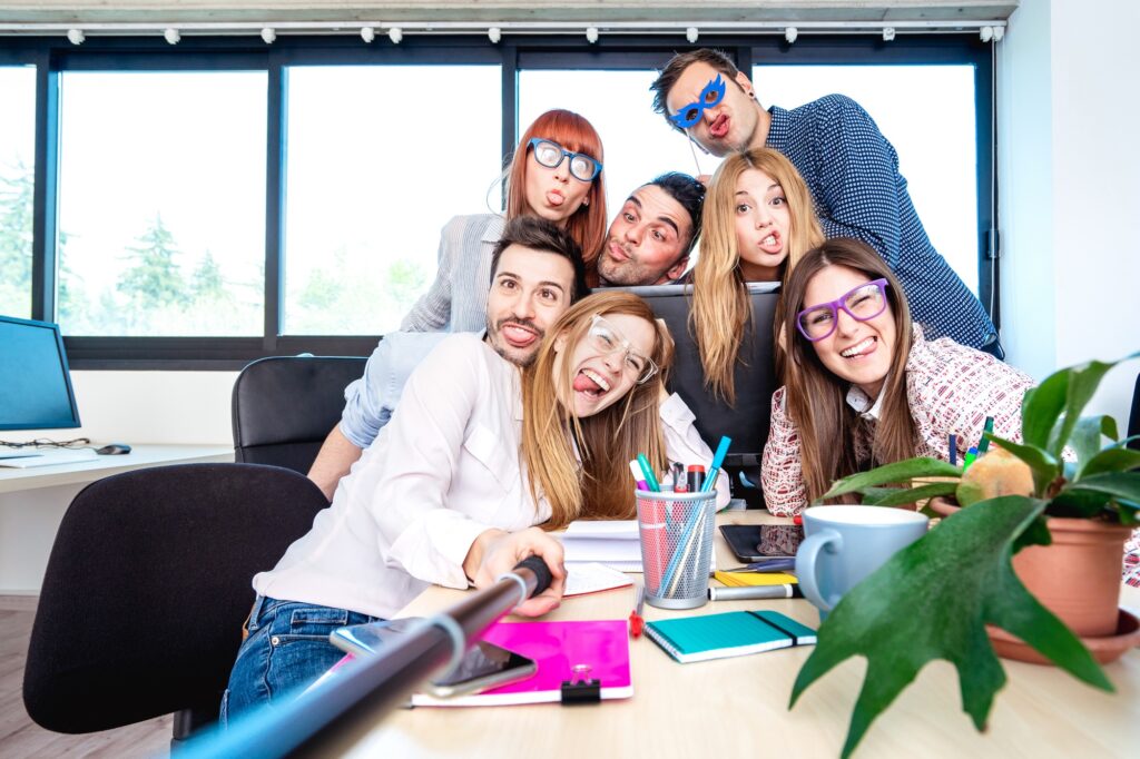 Young people employee workers taking happy selfie with stick